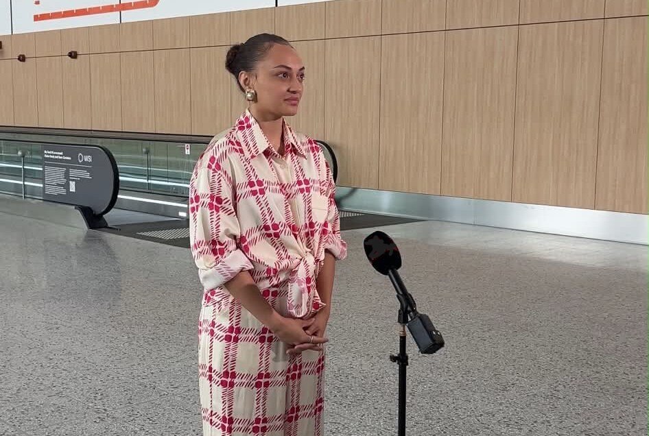 A young woman speaks in an empty airport terminal.
