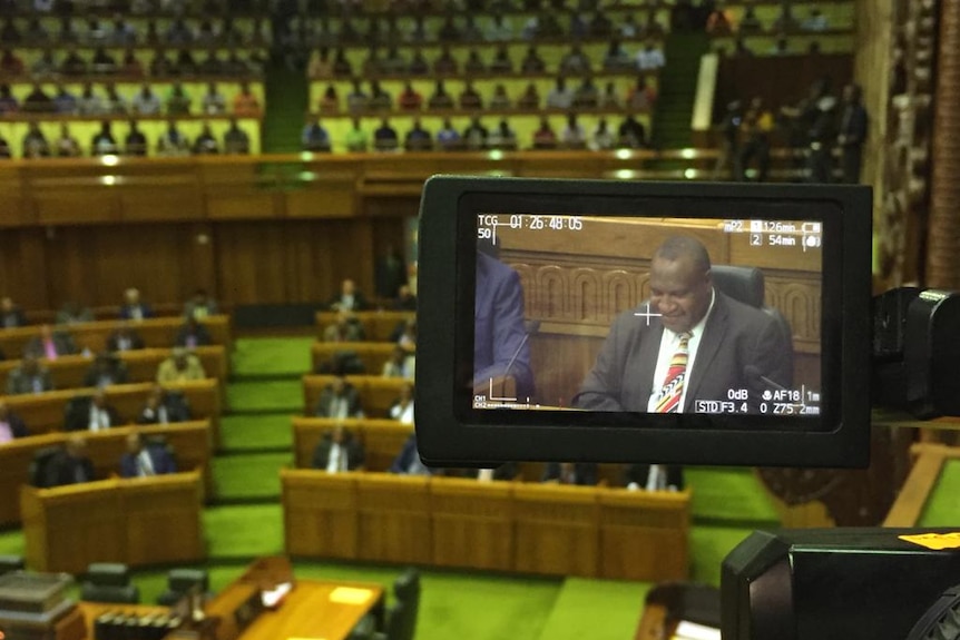 James Marape in the screen of a camera sitting in PNG's parliament.