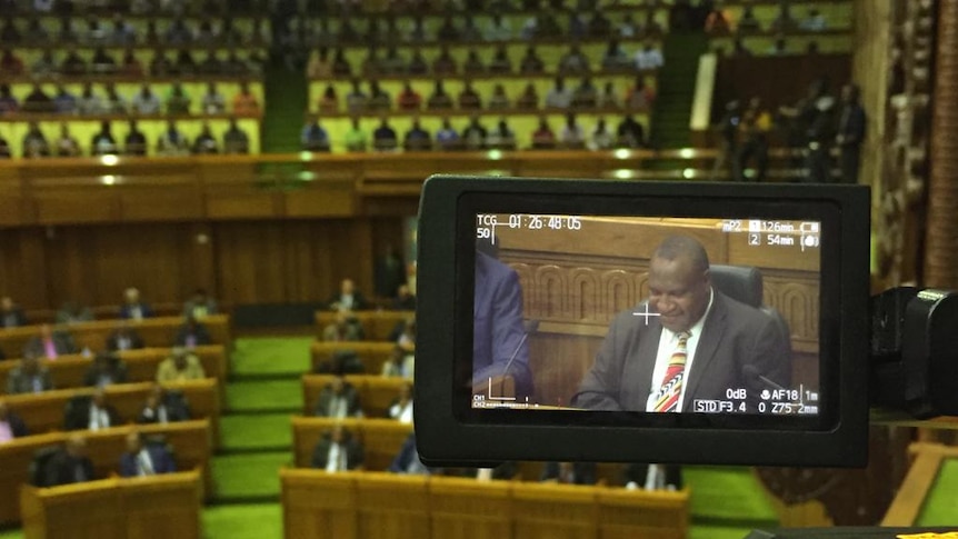 James Marape in the screen of a camera sitting in PNG's parliament.