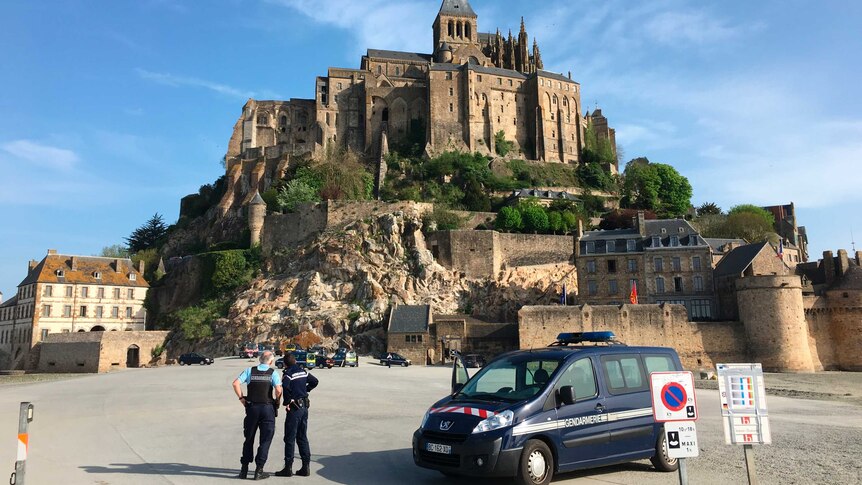 French Police stand in front of a gendarmerie van at the Mont Saint-Michel abbey in France