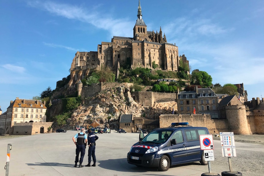 French Police stand in front of a gendarmerie van at the Mont Saint-Michel abbey in France