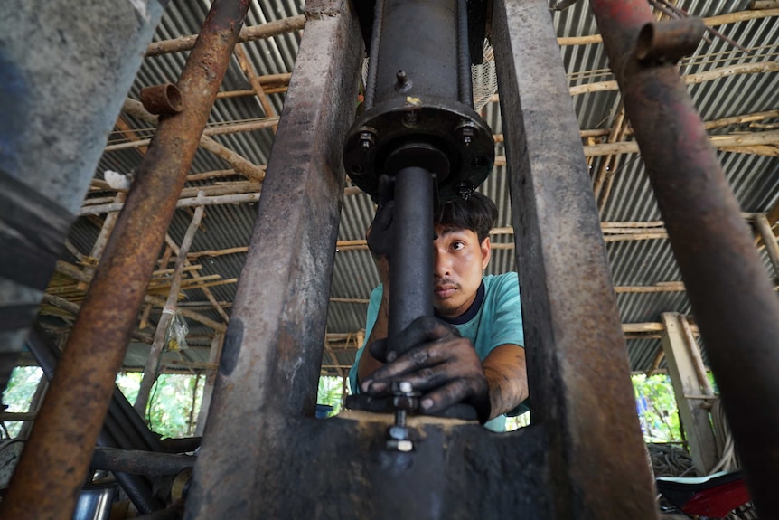 Thamnong Chaiyanit concentrates as he plunges a metre-long drill bit directly into compressed gunpowder