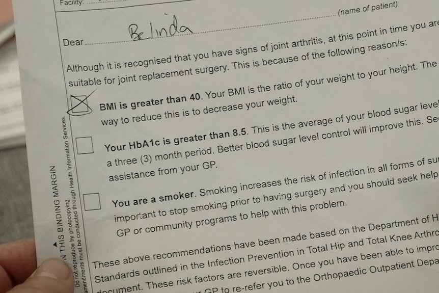 Two hands hold a letter. The text shows the section marked BMI has been ticked. 