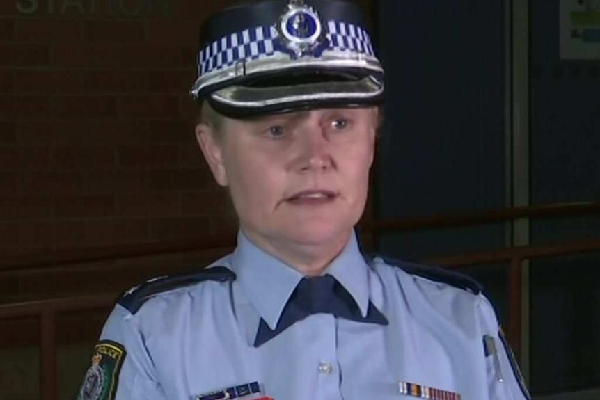 A female police officer with blonde hair looking grim