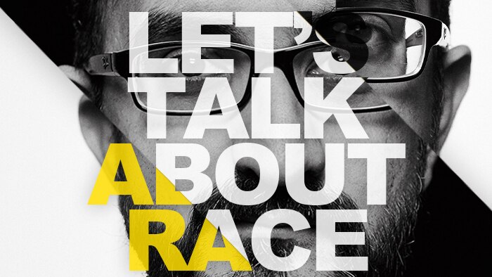 Let's Talk About Race superimposed over a face of a man in glasses