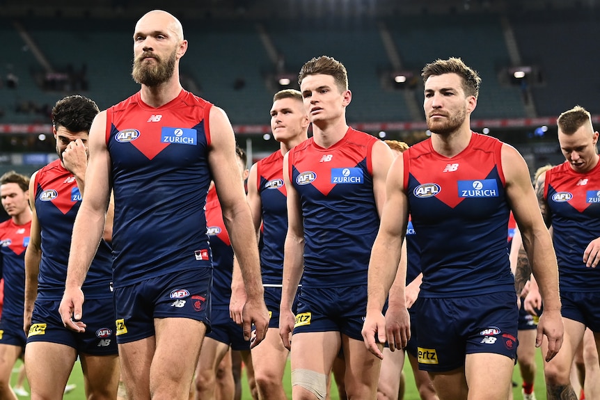 Max Gawn and his Melbourne teammates look disappointed as they leave the field