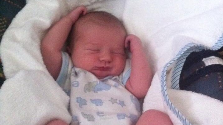 Baby Michael Smedley as a newborn lies sleeping.