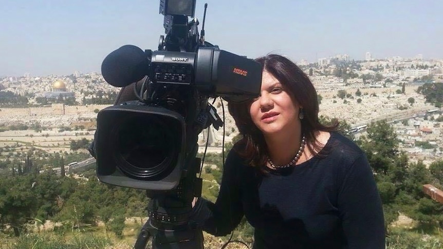 Shireen Abu Akleh, a journalist for Al Jazeera network, stands next to a TV camera