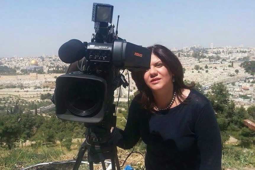 半岛电视台记者 Shireen Abu Akleh 站在电视摄像机旁