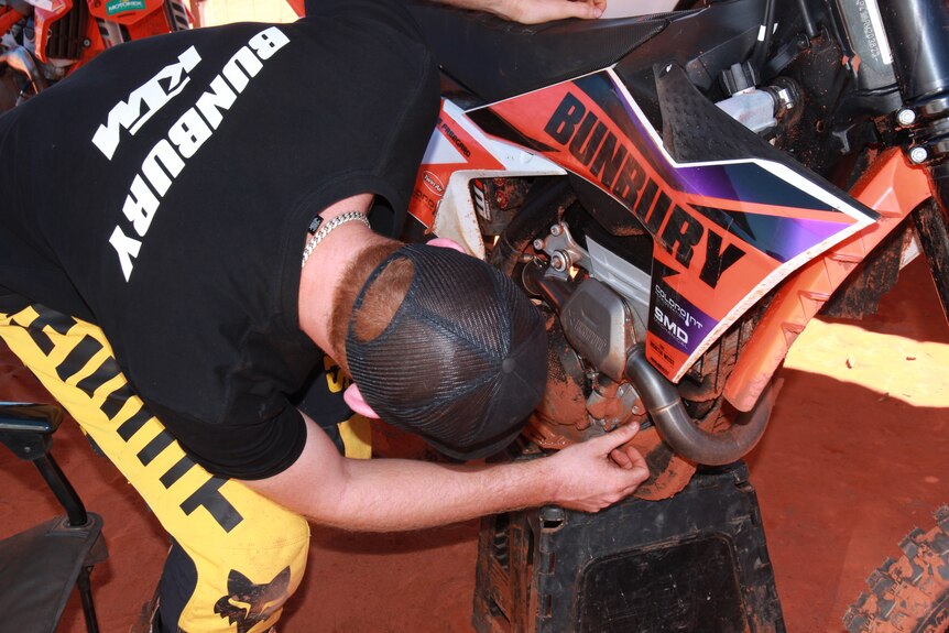 A motocross rider checking his bike before a race