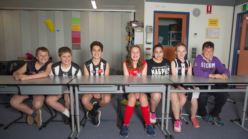 Students at Mickleham primary school sitting at their desks in their footy gear
