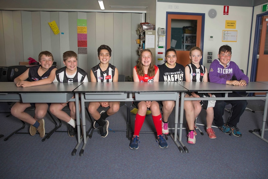 Students at Mickleham primary school sitting at their desks in their footy gear