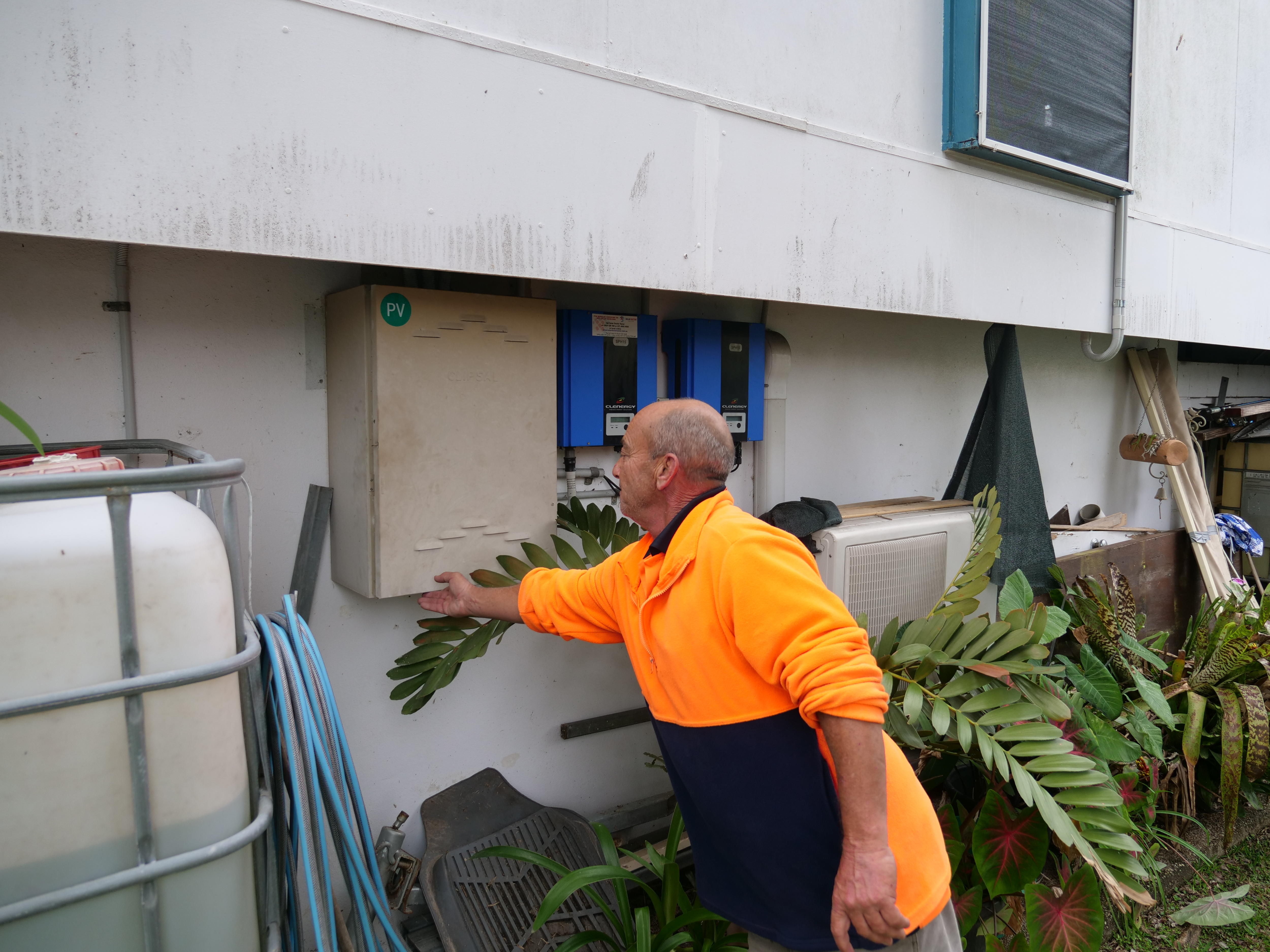 Man in high vis work gear closing his meter box. 