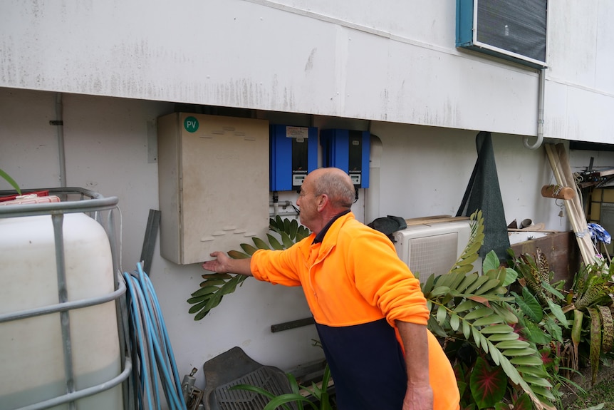 Man in high vis work gear closing his meter box. 