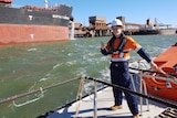 a young man near water in work gear