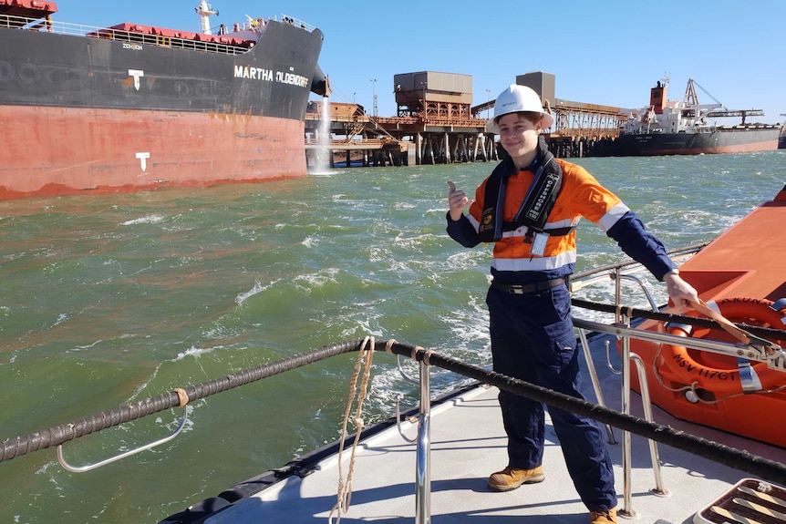 a young man near water in work gear