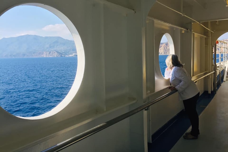 Julie Turnbull looks through a porthole on the cruise ship Costa Victoria.