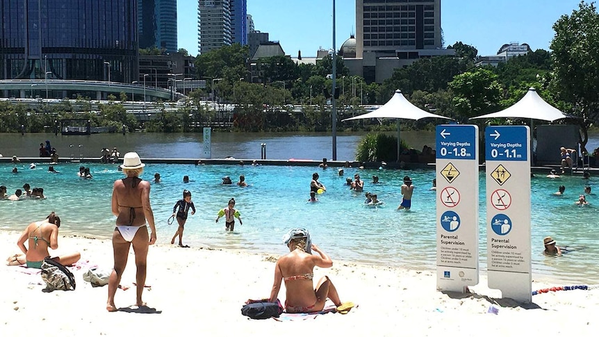 People swim and relax at South Bank beach in Brisbane on February 11, 2017 during a heatwave.