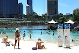People swim and relax at South Bank beach in Brisbane on February 11, 2017 during a heatwave.