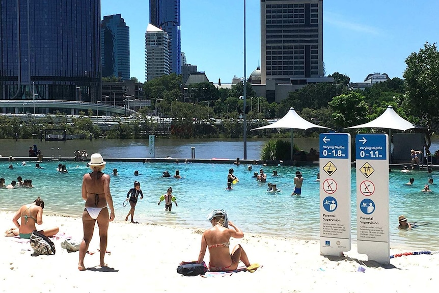 People swim and relax at South Bank beach in Brisbane on February 11, 2017 during a heatwave.