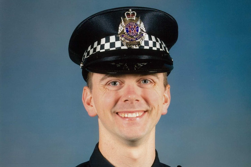 A smiling young man wearing a Victoria Police uniform.