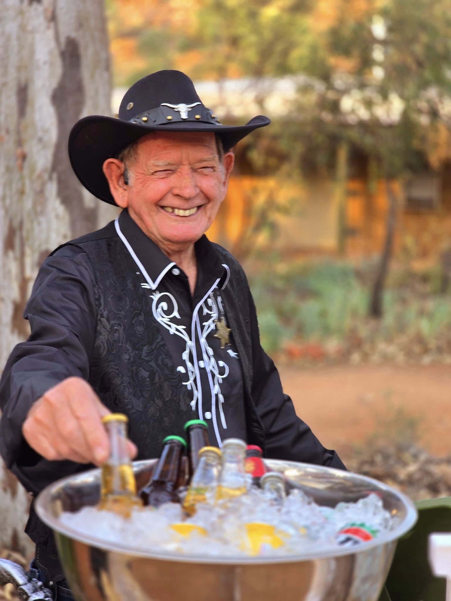 Un hombre vestido con un traje de vaquero del Lejano Oeste toma una cerveza.