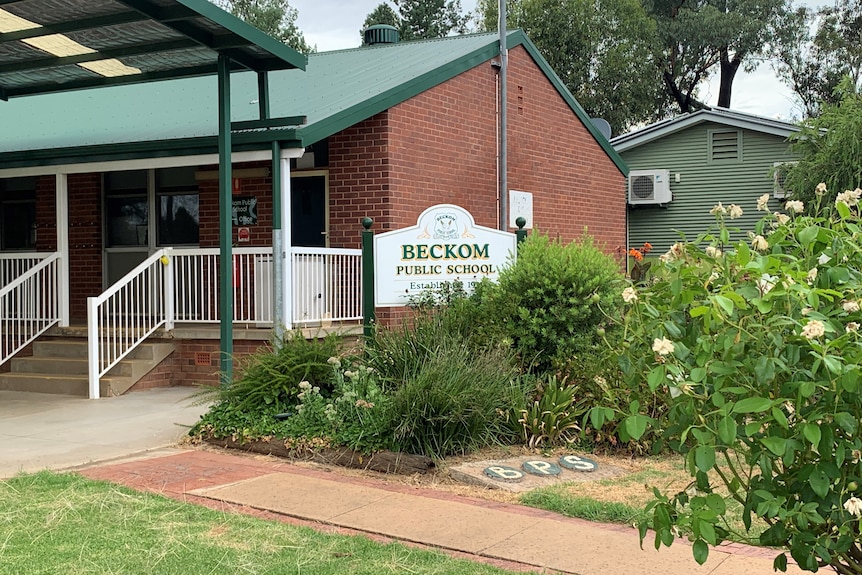 A brick building with a school sign out the front