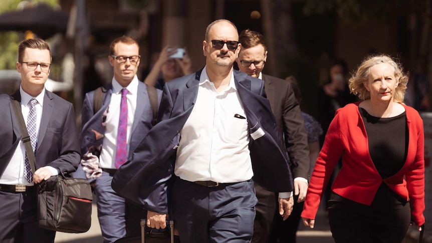 A group of lawyers dressed in suits  outside court.