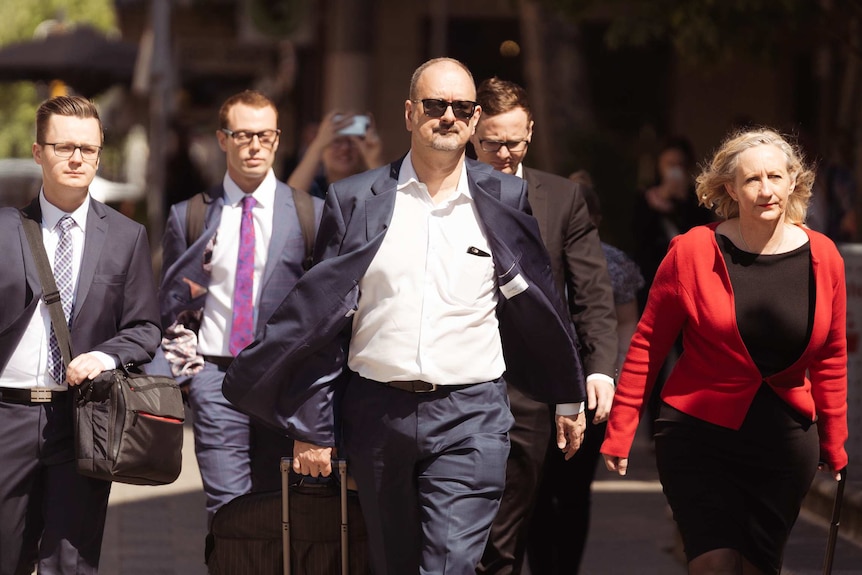 A group of lawyers dressed in suits  outside court.