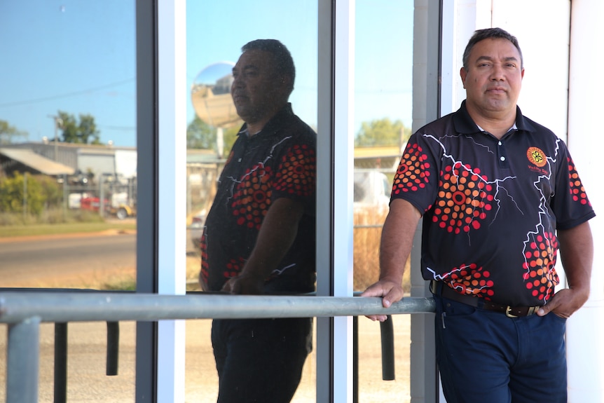 Indigenous Major Brian Pedwell leans against a glass building looking concerned.