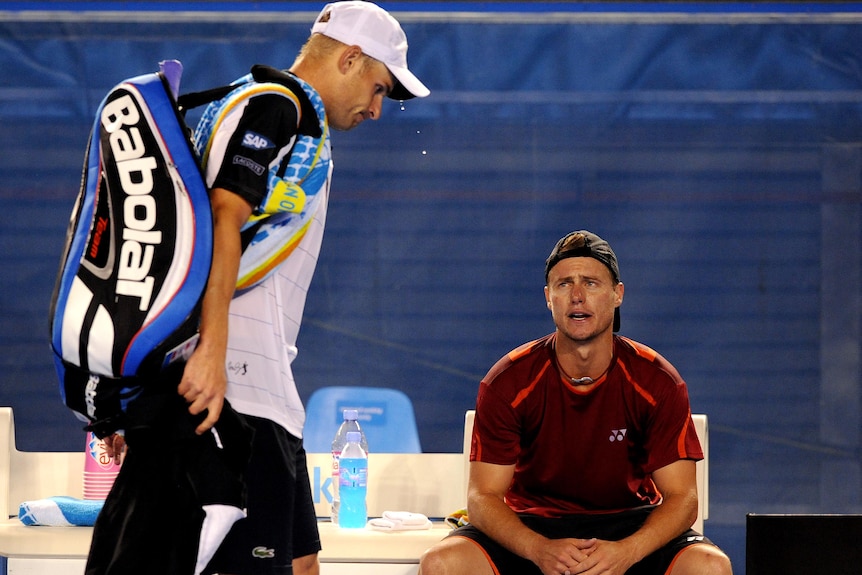Lleyton Hewitt watches Andy Roddick walk off the court. (AAP: Joe Castro)