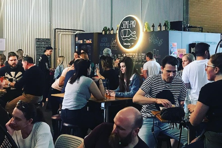 People drinking beer at a brewery.