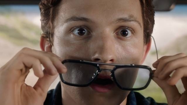 A young man looks surprised as he removed a pair of glasses.