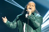 A man in a leather jacket singing into a microphone.