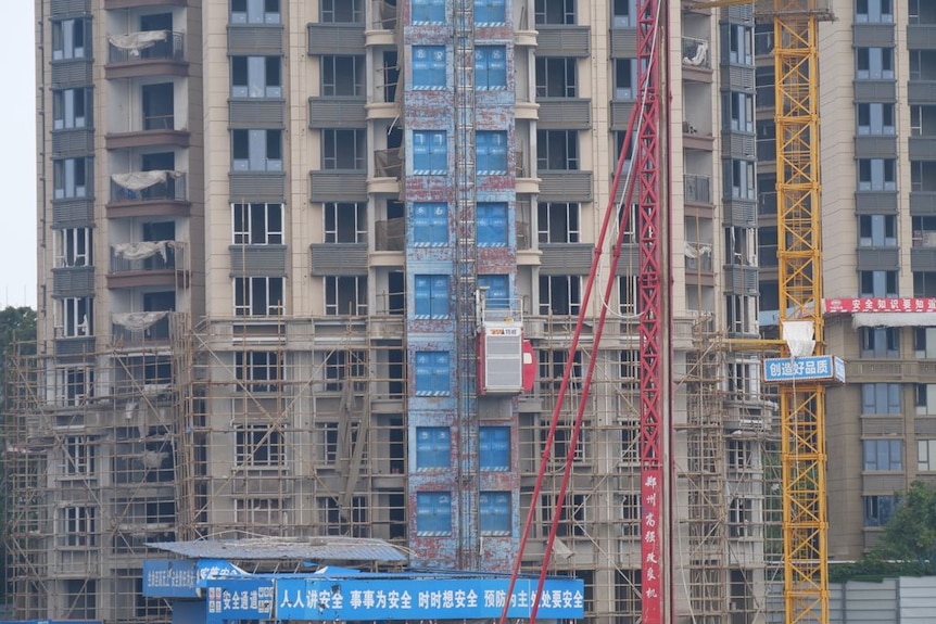 A half finished apartment building, covered in scaffolding 