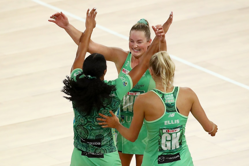 Alice Teague-Neeld hugs some teammates in the middle of the court