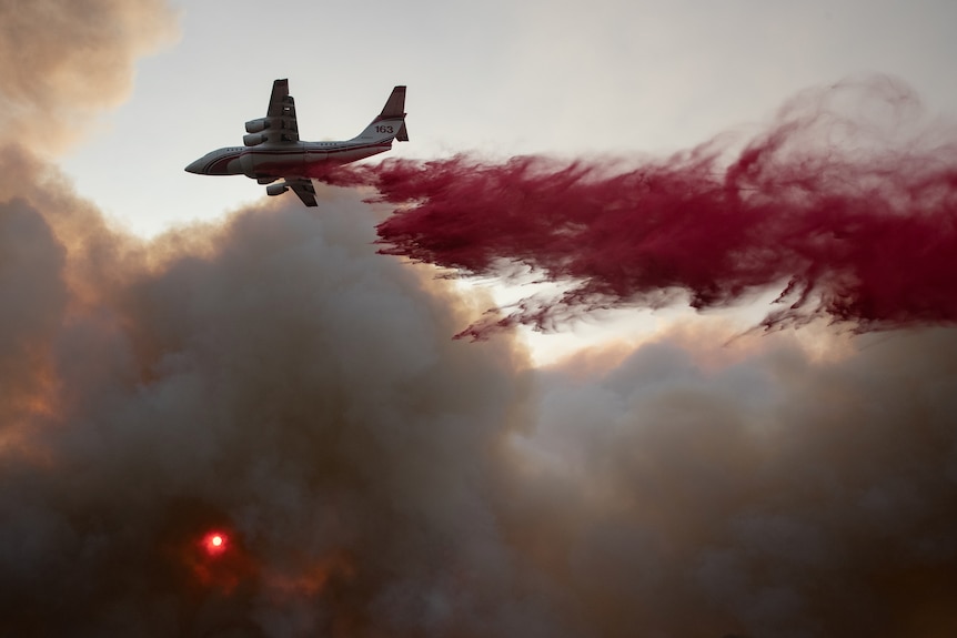 A plane drops red fire retardant on the fires in California, in Sept 2020