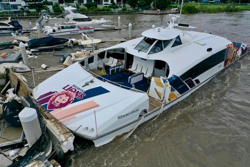 A CityCat ferry is surrounded by flood debris