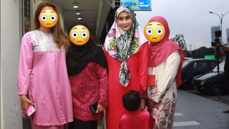四名女性站在一起，其中三名脸上布满了表情符号。  Nur Sajat 身着粉红色连衣裙和花卉头巾