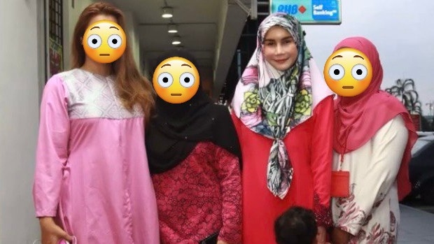 Four women stand together, three whose faces have been covered with emoji. Nur Sajat wears a pink dress and floral head scarf