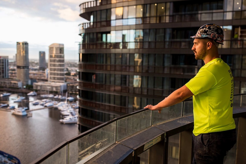 Paul Tzimas surveys the Docklands are of Melbourne from a balcony.