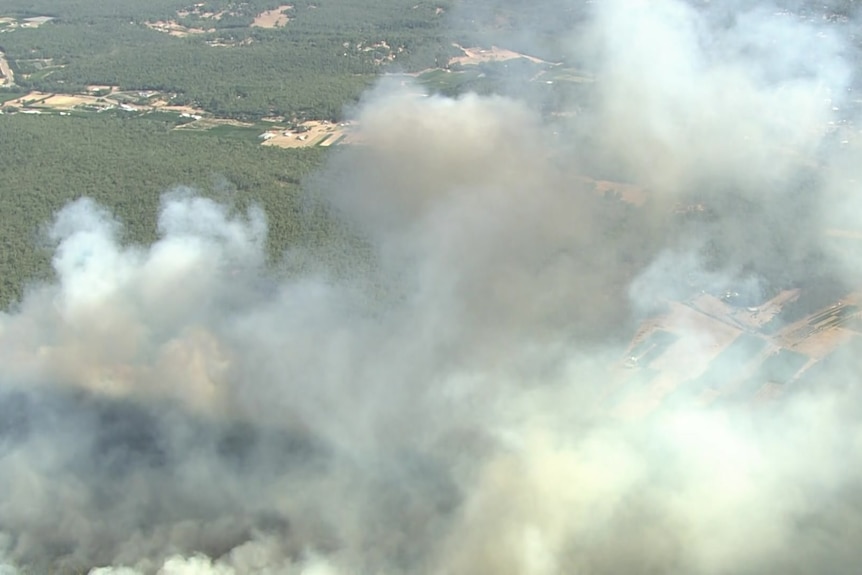 Thick plumes of smoke emanate from a fire