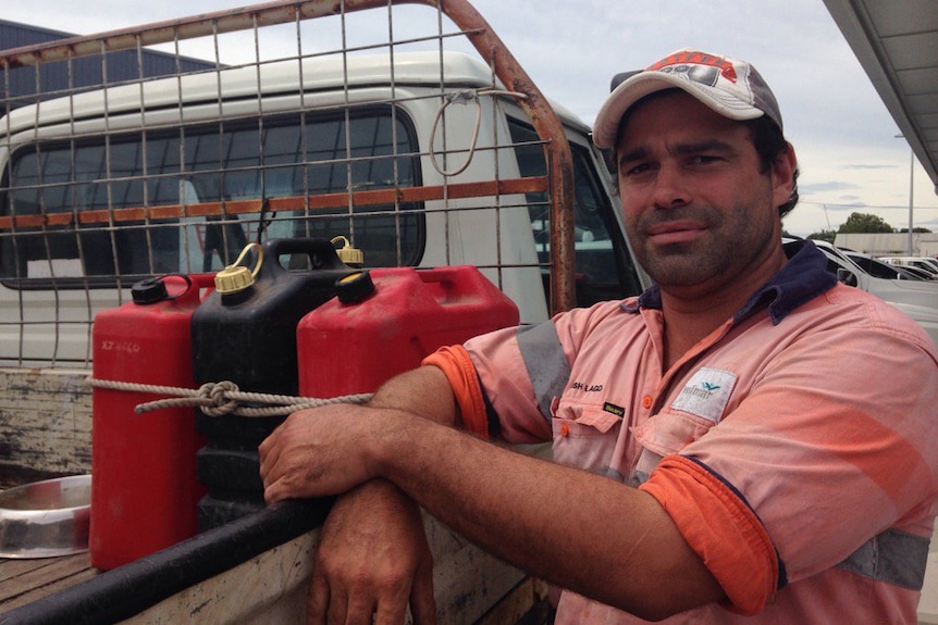 Home Hill local Josh Largo next to three jerry cans of fuel tied to tray of his ute.
