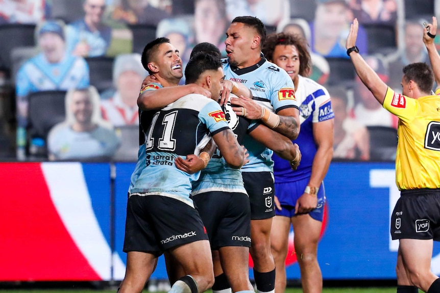A group of NRL players congratulate their teammate after a tryscoring move.