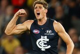 Charlie Curnow flexes his bicep while yelling