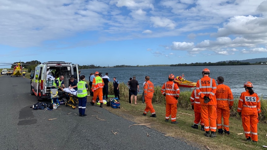 SES and paramedics standing on the bank of the Richmond River in South Ballina.