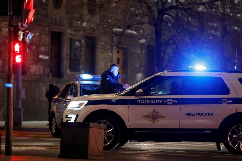 Police block the road with a car to FSB building in Moscow.