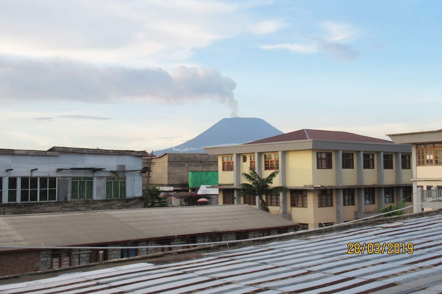 Heal Africa Hospital in Goma in the Democratic Republic of Congo with Nyiragongo volcano smoking in the distance.