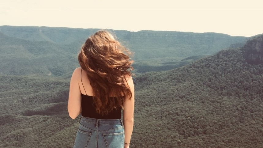 A young backpacker looks out on the Blue Mountains