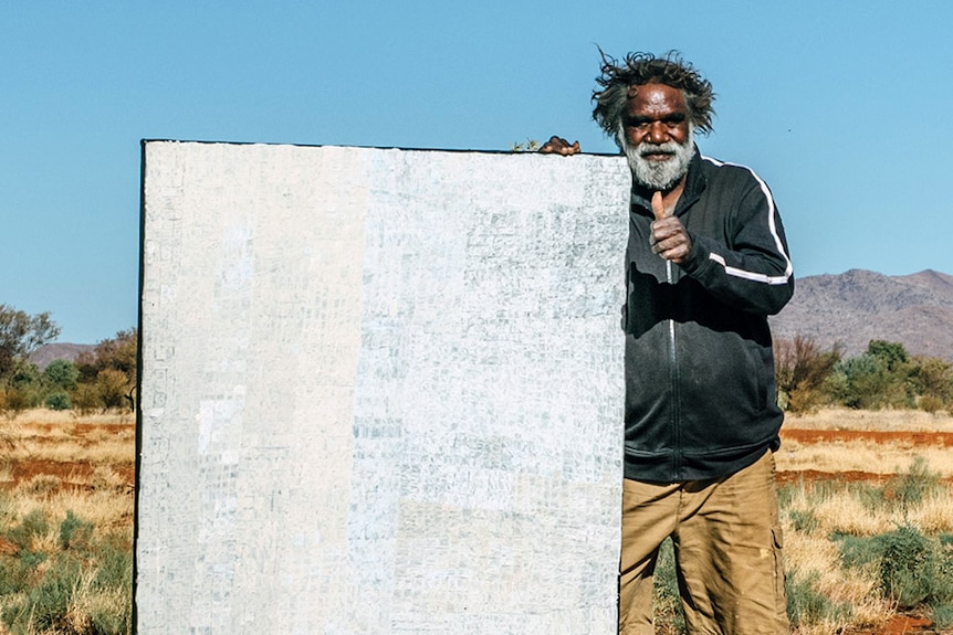 Aboriginal artist Carbiene McDonald Tjangala with his painting